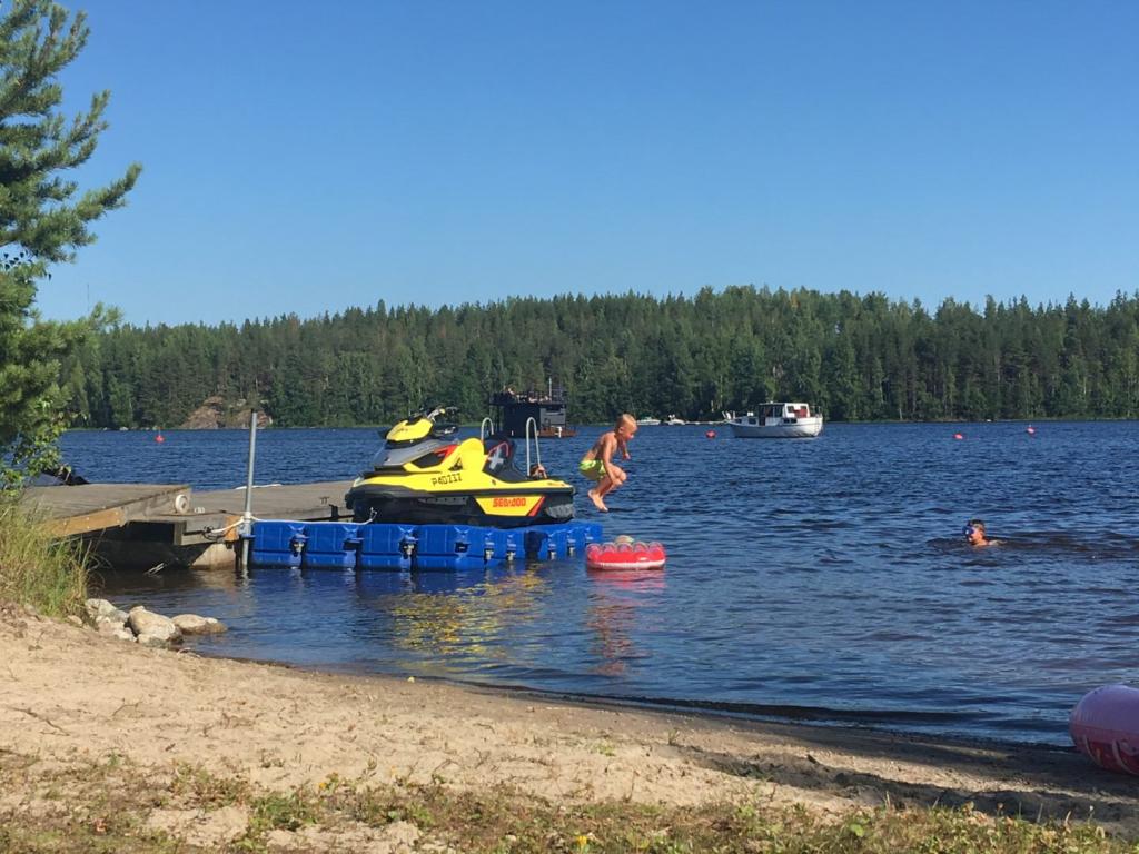Boy dive-bombing into the water, at a beach in Finland.